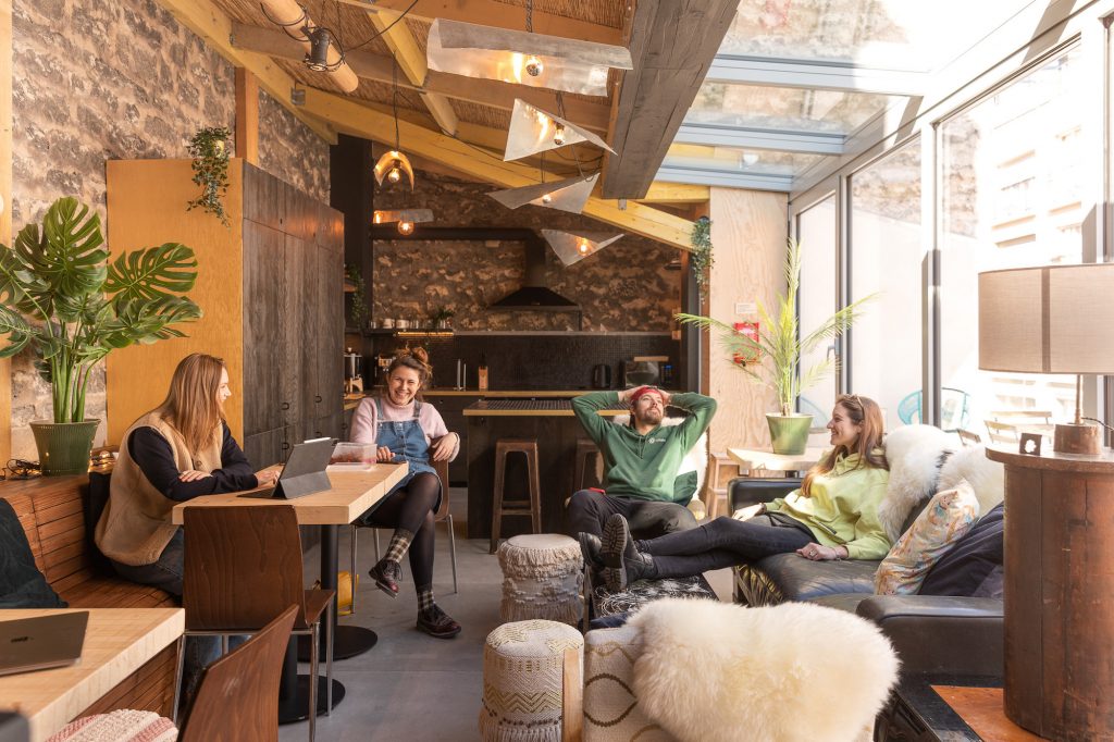People chilling together in a nice and big living room of a premium coliving space in Paris. 